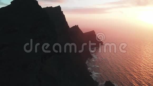 静态鸟瞰长而高的山脉悬挂在汹涌的海洋在日落帕里克自然塔马达巴大加那利岛视频的预览图