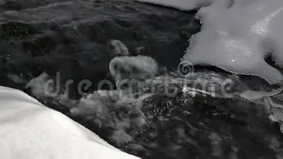 河流遍布冰雪覆盖的融化的雪岸视频的预览图
