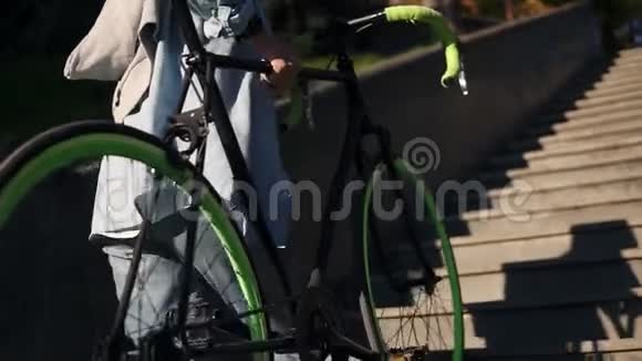 年轻女子骑自行车上楼抱着自行车骑自行车的女人走上楼梯牵着他的手视频的预览图