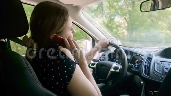 不负责任的女司机开车时通过电话交谈的慢动作视频使用免提安全视频的预览图