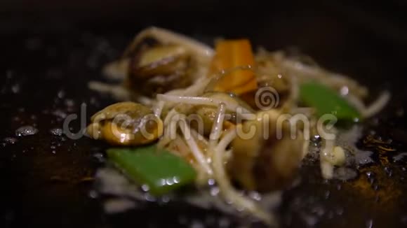 4K菜海食品厨师在厨房里烤着蔬菜煮蛤蜊视频的预览图