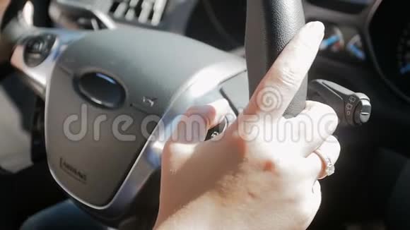 方向盘和驾驶车上女司机预置旋钮的特写慢动作视频视频的预览图