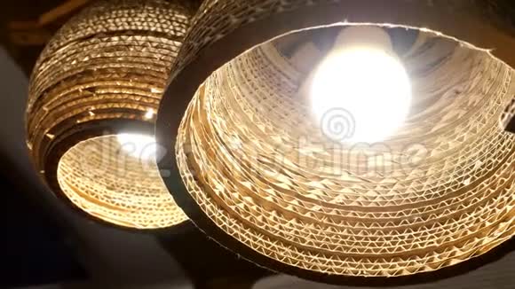 棕色柳条吊灯有明亮的发光灯在天花板上发光微微摇曳特写镜头视频的预览图