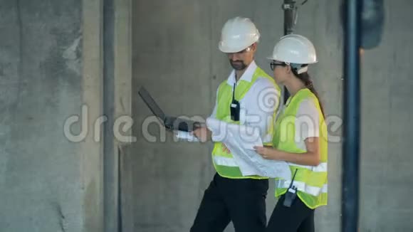 工程师带着笔记本电脑在未完工的大楼里行走侧视视频的预览图