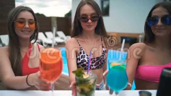 女孩们在度假泳池酒吧喝鸡尾酒慢动作视频的预览图