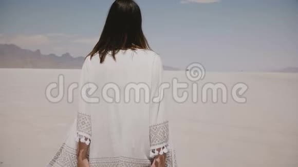 美丽的年轻快乐的女人在阳光明媚的炎热的邦尼维尔盐沙漠湖散步和旋转穿着轻便的便服视频的预览图