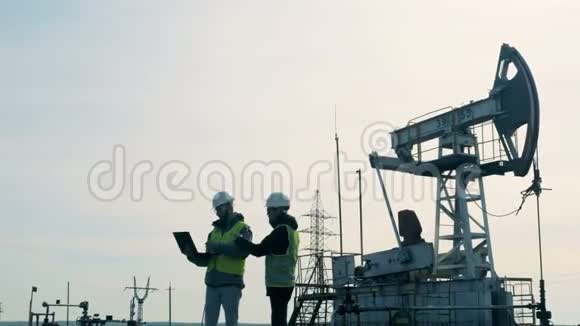 与两名工程师交谈的大型石油生产现场视频的预览图