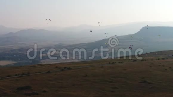 在2019年8月的夏季几架滑翔伞正在日落谷上空飞行山峦叠嶂视频的预览图