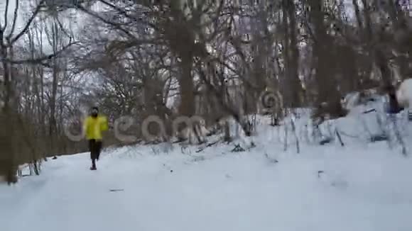 在冬季森林里一个长胡子的运动员从山上跑下来视频的预览图