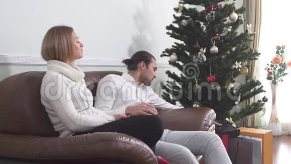 英俊的男人给他妻子圣诞礼物女人打开盒子惊讶于里面的东西恋爱关系视频的预览图