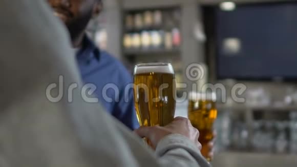 多种族男性朋友在酒吧柜台碰杯啤酒放松一下视频的预览图