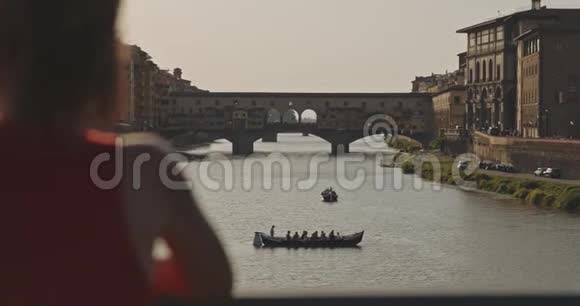 女游客看着漂浮在河上的船视频的预览图