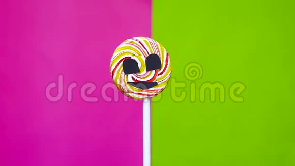 一种棒棒糖其形象是一张积极的脸在明亮的背景下旋转糖的影响概念视频的预览图