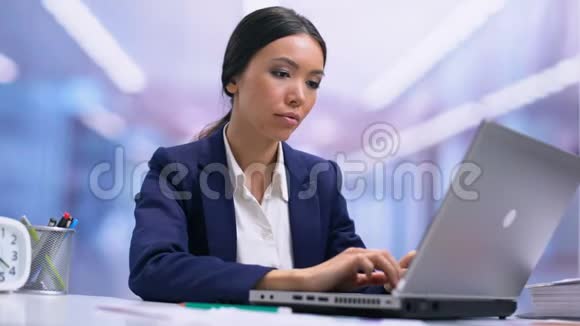 疲惫的商务女性颈部疼痛坐在前手提电脑医疗保健视频的预览图