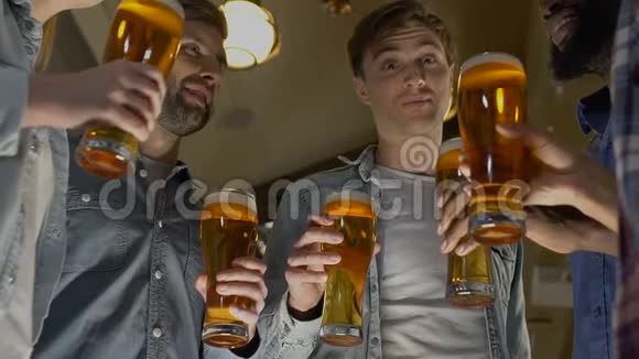 快乐的一群朋友碰着啤酒杯在酒吧庆祝生日视频的预览图