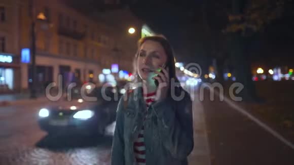 女人在智能手机上说话走在城市的街道上视频的预览图