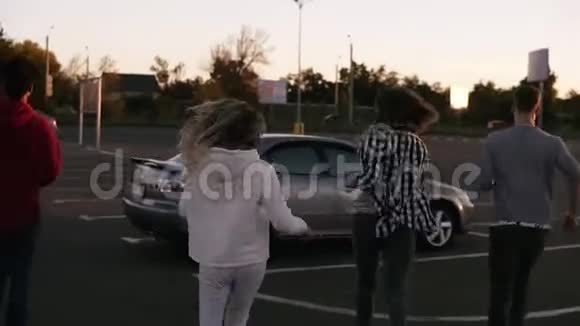 一个多种族时尚的年轻四个朋友在购物中心停车区跑步坐在银色的车里这是罕见的景象视频的预览图