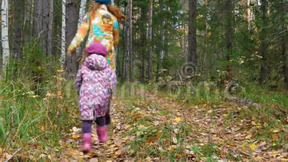 妈妈和女儿正沿着森林里的小路跑视频的预览图