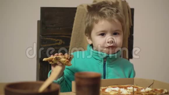可爱的白人小男孩吃披萨饿孩子吃披萨吃披萨的小男孩饥饿视频的预览图