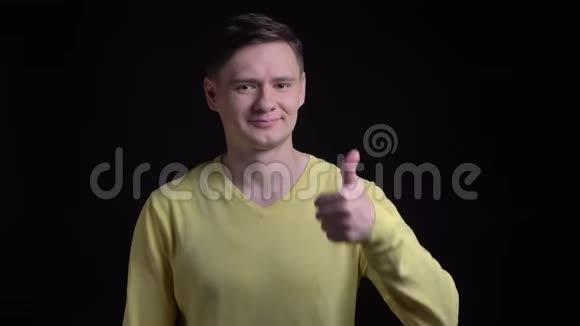穿着黄色毛衣的中年白种人用手指示意在黑色镜头上表示喜欢和尊重视频的预览图