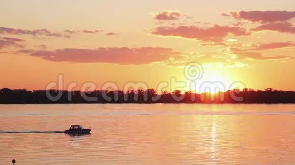 令人惊叹的湖泊景观海岸线漂浮的船只在美丽的橙色日落视频的预览图