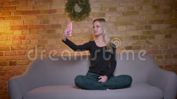 年轻女学生在手机上自拍在镜头前微笑摆姿势的特写镜头视频的预览图