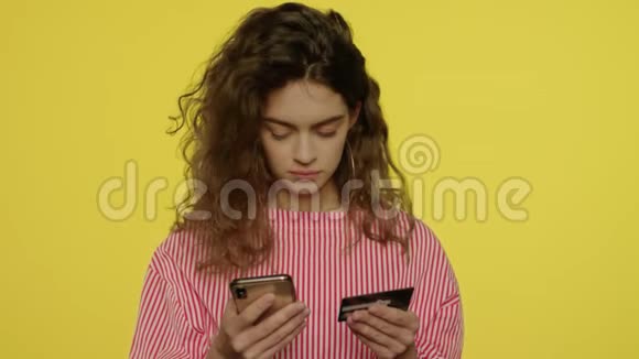 年轻女子在网上购物时在手机上输入信用卡号码视频的预览图