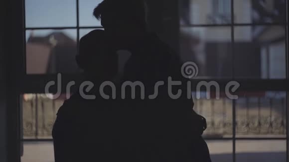 黑暗中的老夫妇剪影女人和男人用爱和温柔拥抱和抚摸在一起视频的预览图
