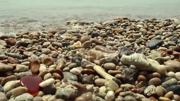 海浪拍打着满是沙砾的沙滩视频的预览图