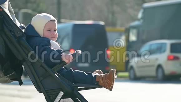 小男孩坐在婴儿车里车上有车视频的预览图