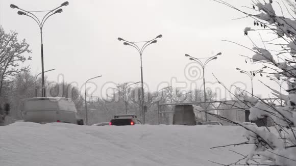 汽车在雪堆后面的冬季城市道路上行驶第1部分视频的预览图