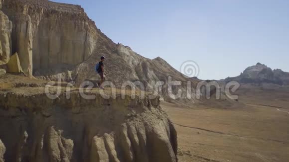 一个年轻的旅行者站在悬崖边喝水视频的预览图