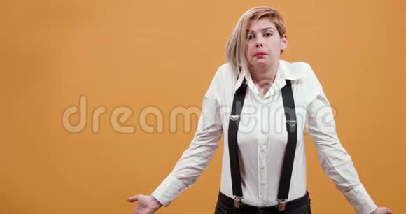 一个金发女人被迷惑并张开双臂的中型肖像视频的预览图