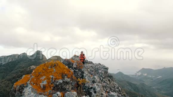年轻女子在高山上的仙人掌中行走在山顶上欣赏美景的女士视频的预览图