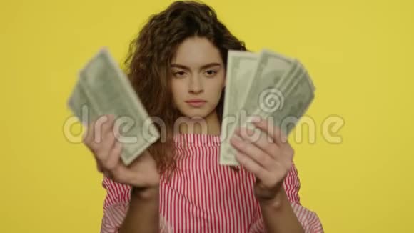 在黄色工作室数现金的年轻女子有钱的女孩数现金视频的预览图