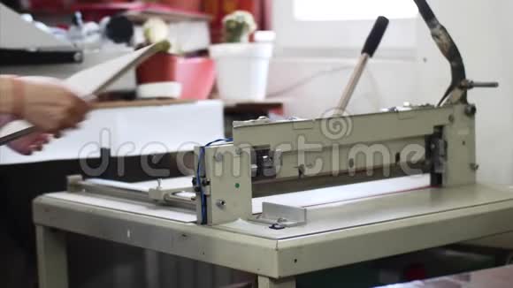 妇女切纸板在手动切纸机在排版视频的预览图