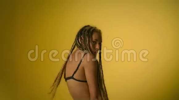 迷人的女人在黄墙背景上跳舞肖像女青年视频的预览图
