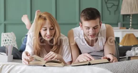 女孩和男孩正在一起大声地躺在床上看书视频的预览图