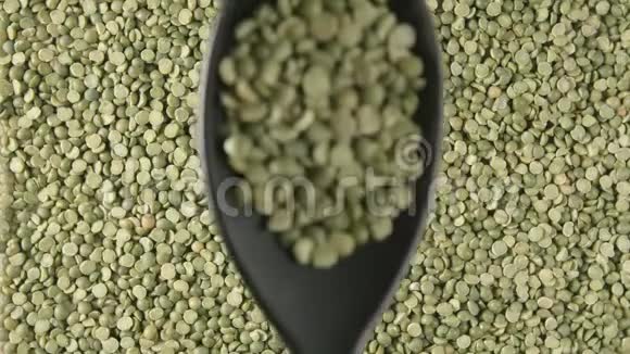顶部视图带绿色豌豆的勺子缓慢地落在绿色豌豆上视频的预览图