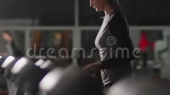 漂亮年轻的女孩在健身房跑步机上跑步视频的预览图