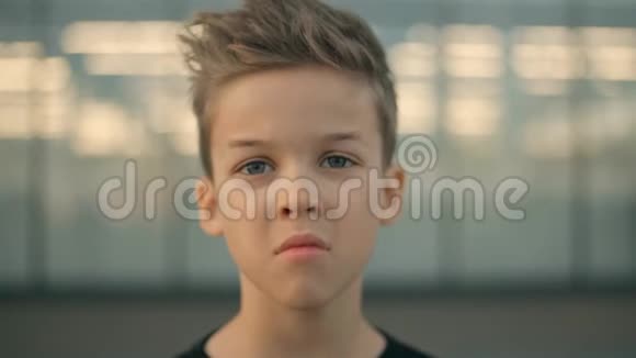 悲伤的男孩在思考看着相机一个严肃悲伤的男孩的脸特写肖像视频的预览图