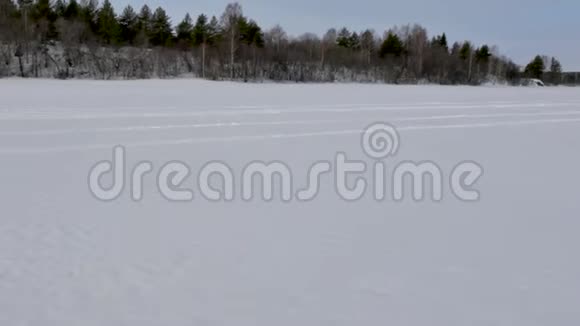 雪上摩托沿着被铁轨划过的广阔雪谷行驶视频的预览图