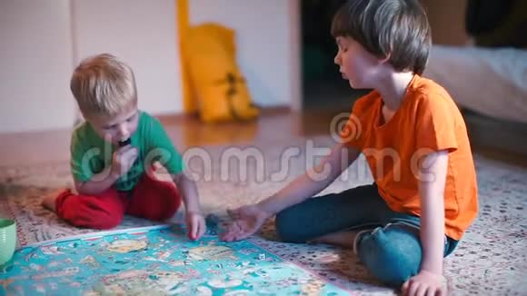两个男孩在家在地板上玩游戏视频的预览图