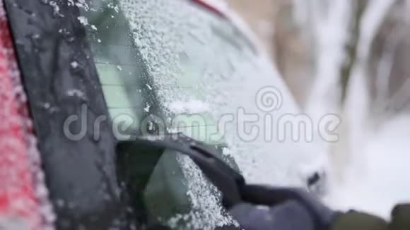 行程前用刮冰机清洗雪后车窗人从汽车后窗雨刮器中取出冰男性视频的预览图