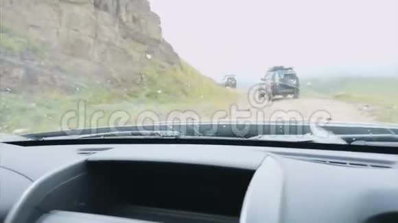 在山上吉普车从越野车的挡风玻璃上看到吉普车和岩石视频的预览图