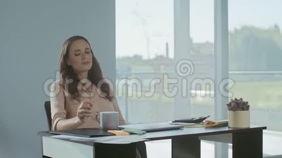 商务女性用咖啡放松疲惫的女士坐着笔记本电脑视频的预览图