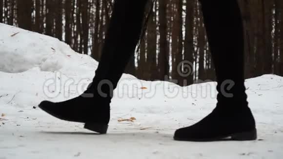 女人穿着靴子雪漠上行走的特写镜头视频的预览图