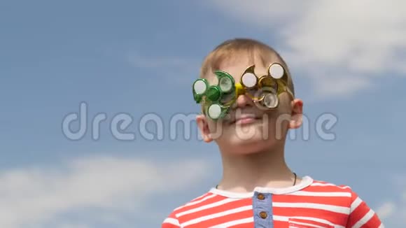 眼镜上的旋转器在旋转在街上玩得很开心小男孩对抗蓝天视频的预览图