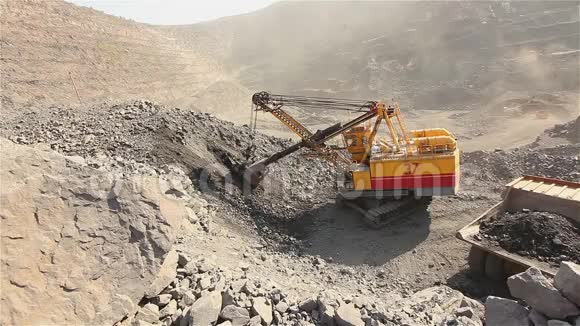 挖土机和翻斗车在采石场大型黄色挖掘机将矿石装入翻斗车工业外部视频的预览图