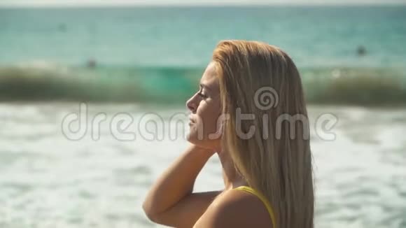 金发女人站在海边她的头发在缓慢地飘动女孩花时间在视频的预览图